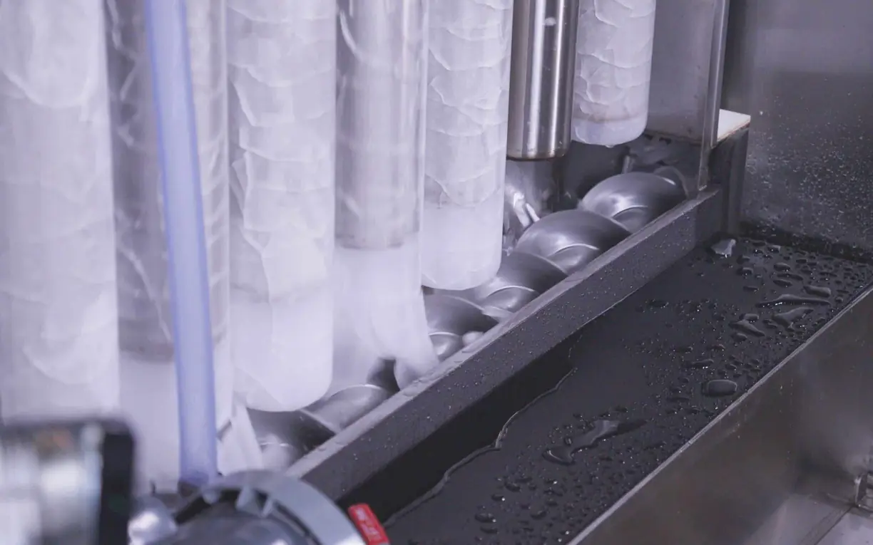 Commercial cracked ice machine manufacturer Ice forming on evaporator tubes above the cutter screw inside an ice machine, with water droplets on the tray