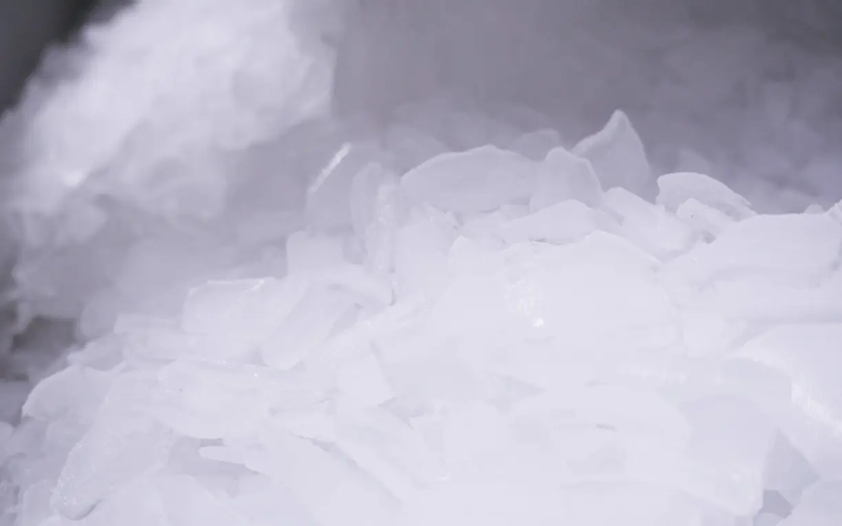 High volume commercial cracked ice machine Pile of freshly made hard cracked ice pieces with cold vapor drifting behind it