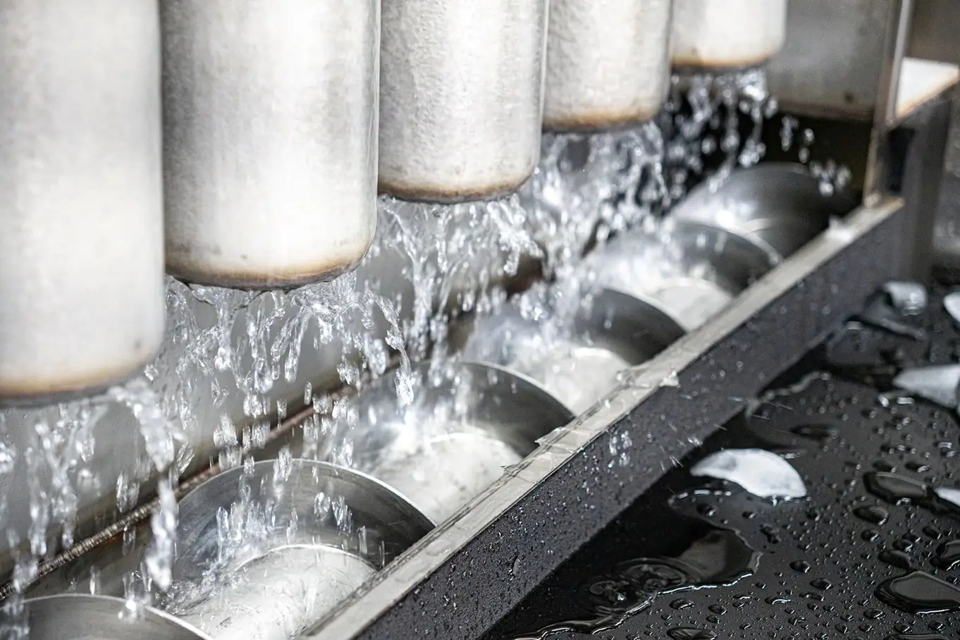 Water streaming from ice-coated evaporator tubes onto the cutter screw inside an ice machine